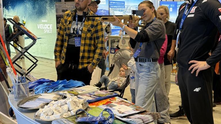 Trzy osoby w tym jedna strzela z broni teningowej, stacji do ćwiczeń triatlonu.jpeg